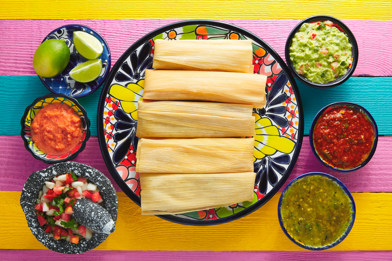 Tamale with corn leaf and sauces guacamole