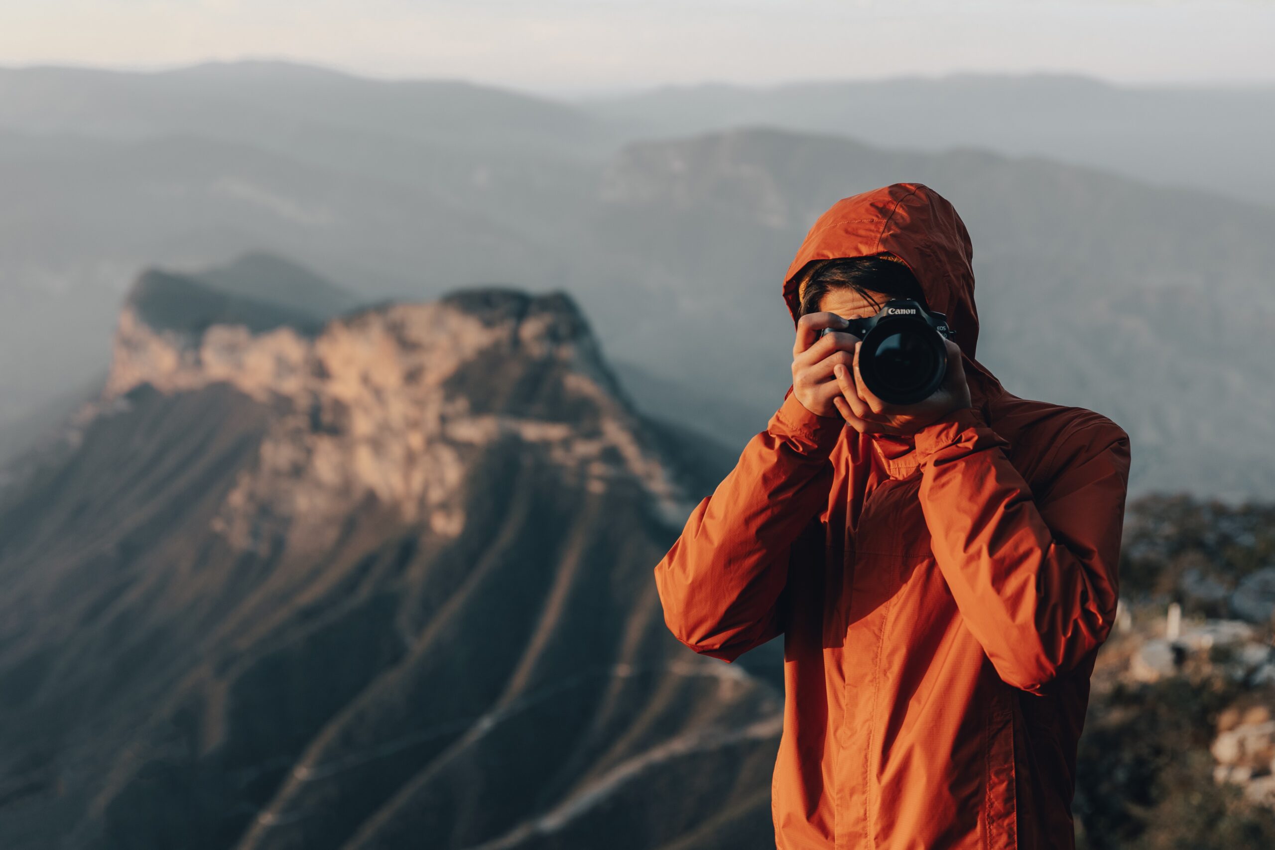A man in the mountains taking a photo